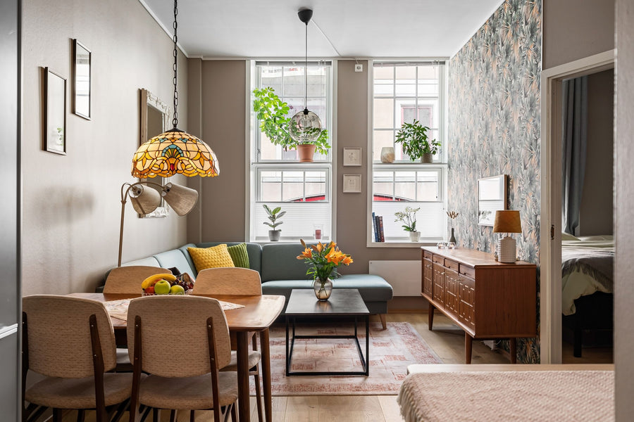 Einrichtungsstile im Überblick: Wohnraum im Stilmix mit Mid-Century-Sideboard, Tiffany-Lampe, Dschungeltapete und Pflanzen