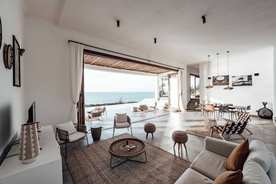 Helle Ferienwohnung mit offenem Wohn- und Essbereich, Rattanmöbeln, Juteteppich und weitem Blick aufs Meer